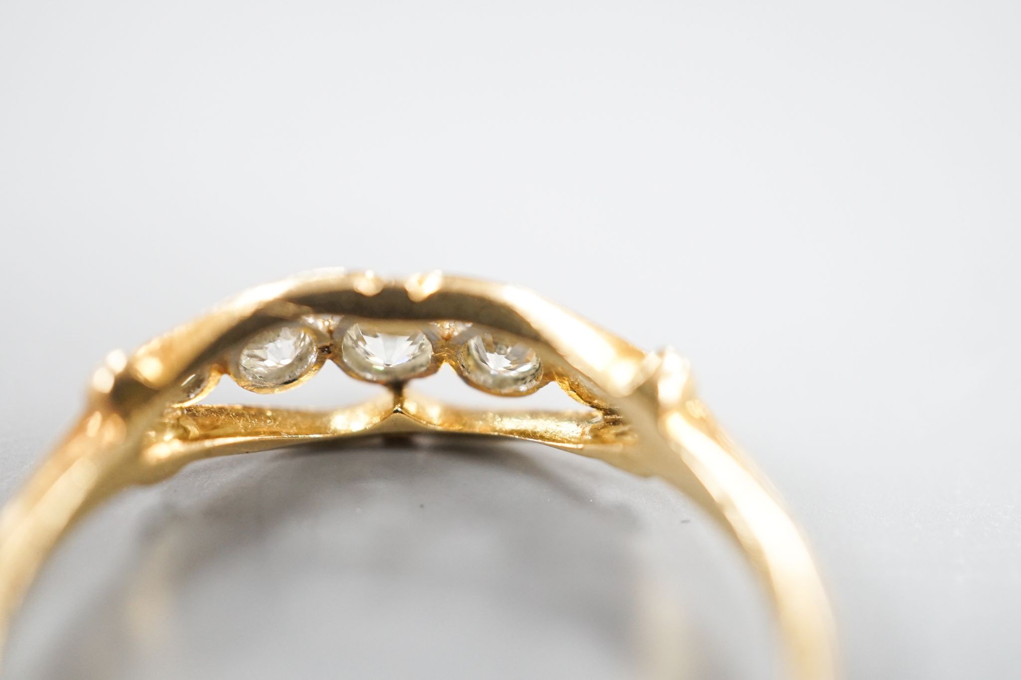 An 18ct and graduated five stone millegrain set diamond ring, size U/W, gross 2.6.